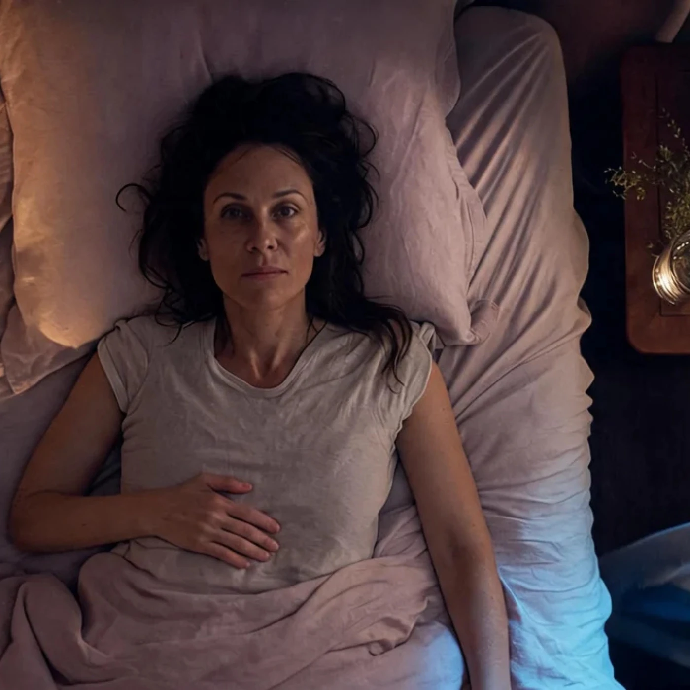 Woman lying awake in bed at night, looking up